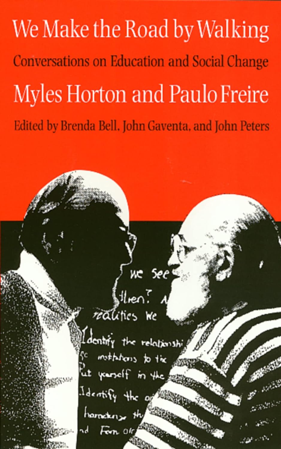 Red and black cover with black and white photograph of Myles Horton and Paulo Freire facing each other. Text at the top reads the title of the book "We Make the Road by Walking: Conversations on Education and Social Change" by Myles Horton and Paulo Freire edited by Brenda Bell, John Gaventa, and John Peters.